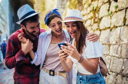 three person looking at a mobile phone
