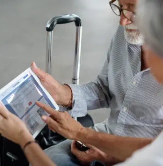 an elderly couple holding a tablet