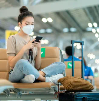 a woman sitting while holding a mobile phone