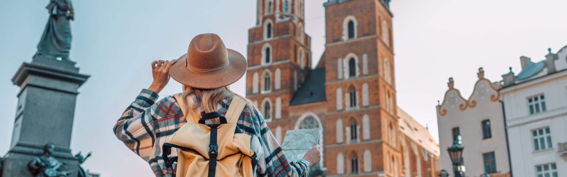 Back view of traveller woman walking on old Market Square in Krakow